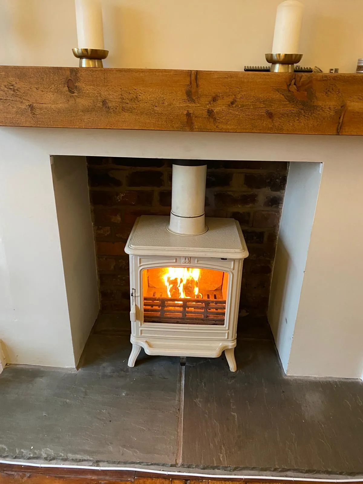 Cream stove with wooden beam mantel