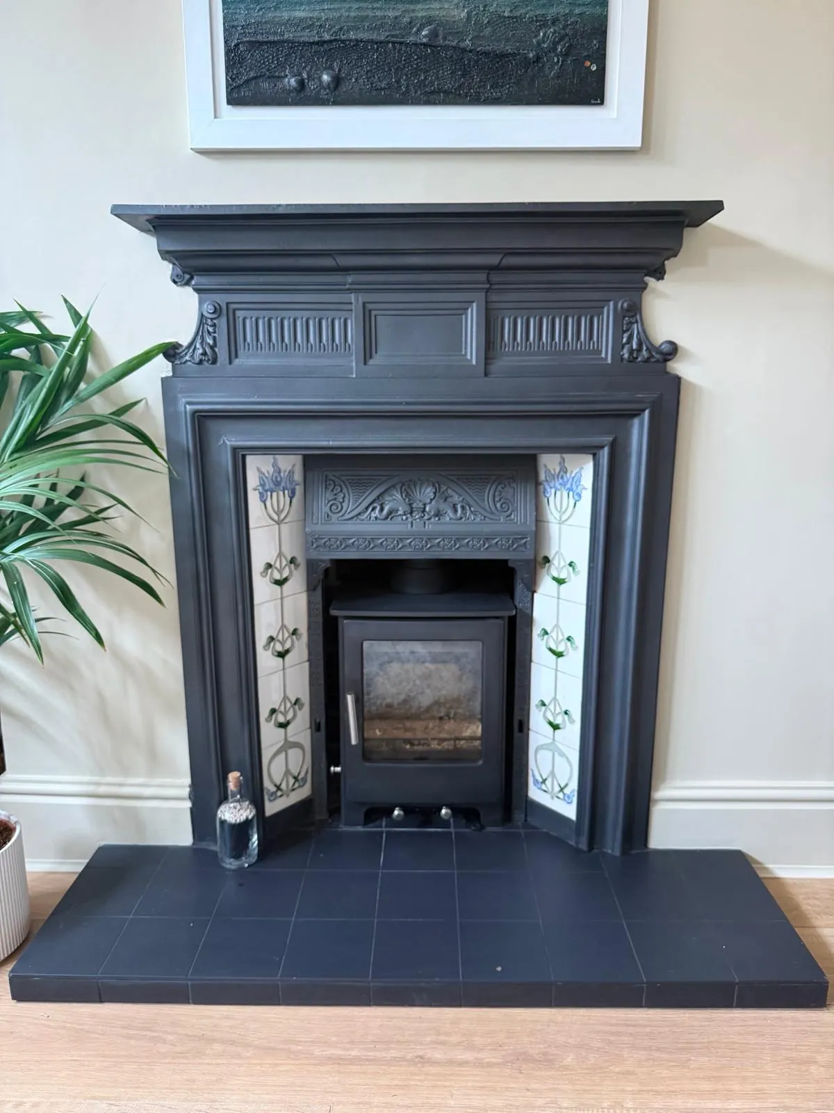 Inset stove within a Victorian cast-iron fireplace with Art Nouveau tiles