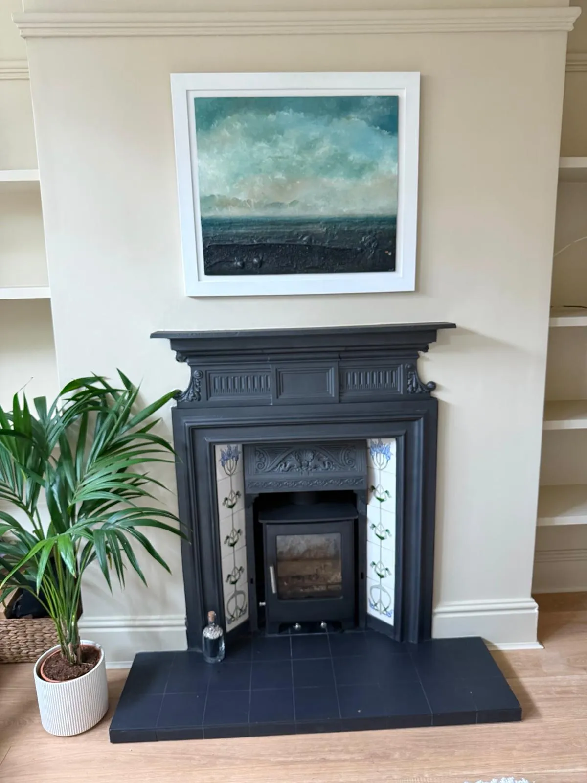 Restored cast-iron fireplace with inset stove and floral tile panels