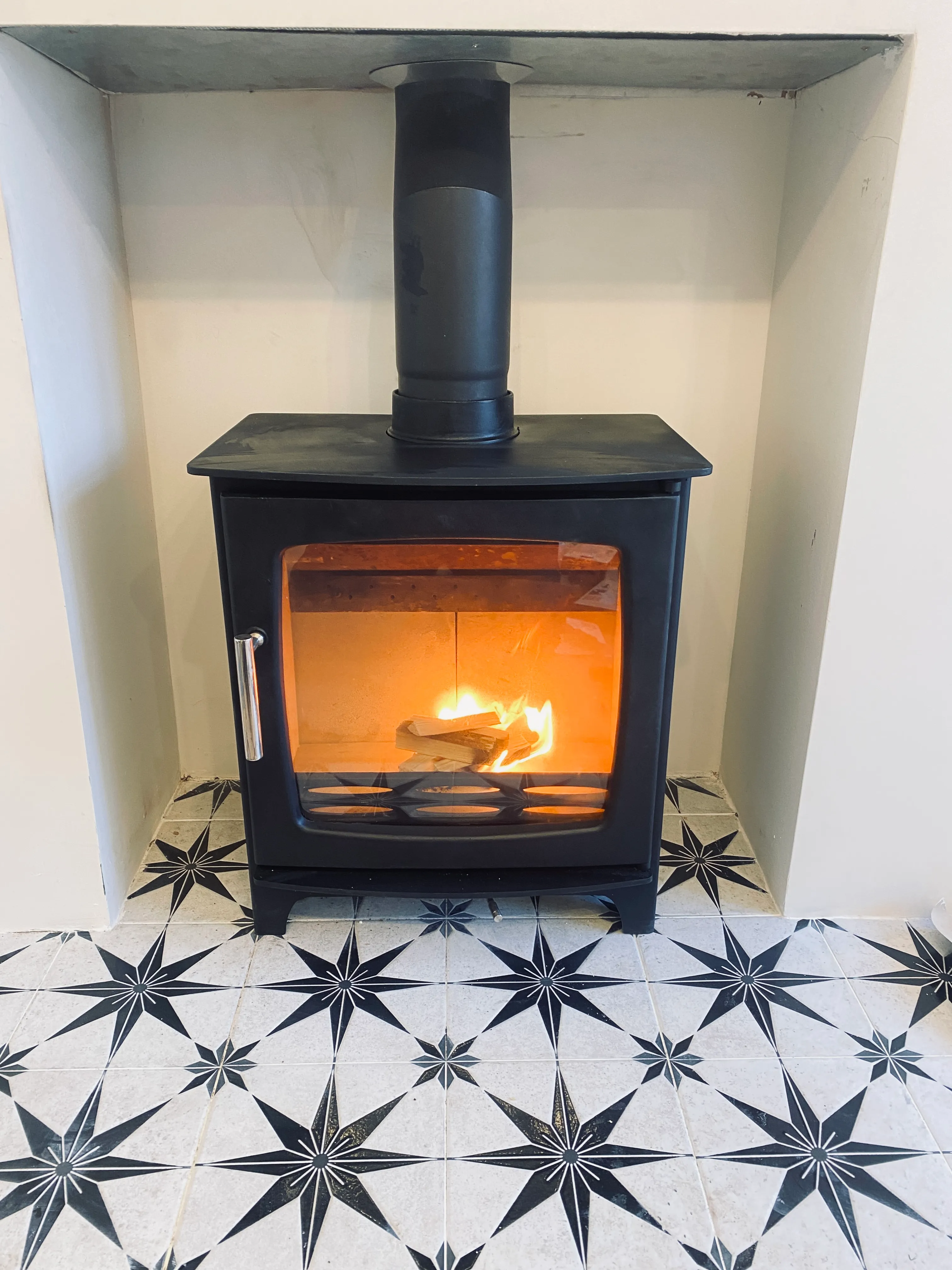 Contemporary black stove on star-patterned tiled hearth