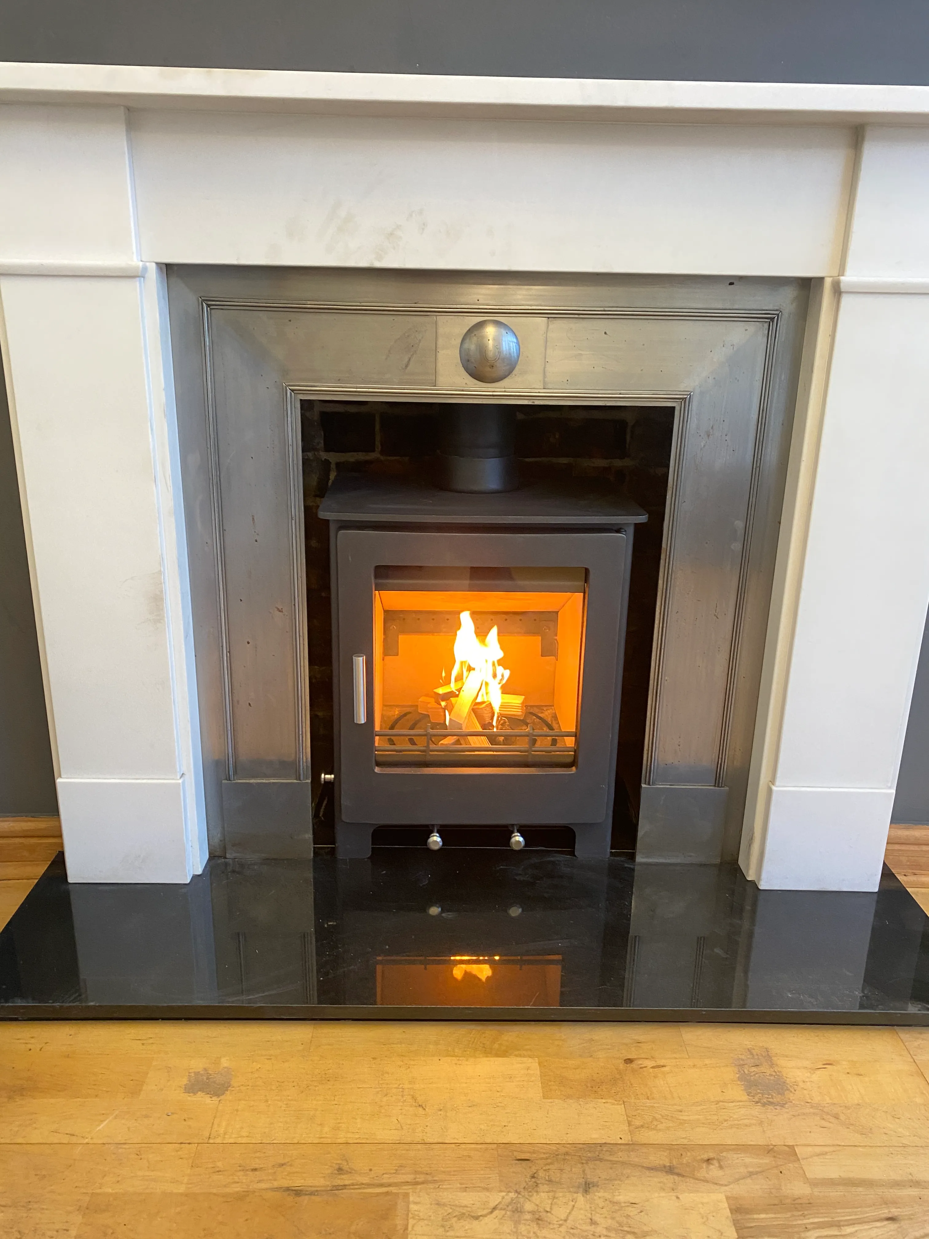 Inset stove within a stone fireplace surround